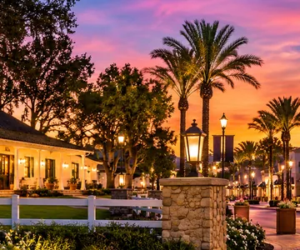 Panoramic evening illustration of Camarillo Ranch House and Camarillo Premium Outlets illuminated at sunset in Camarillo, Ventura County, California.