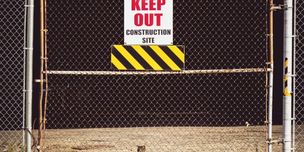 Secured construction site entrance with restricted access warning sign